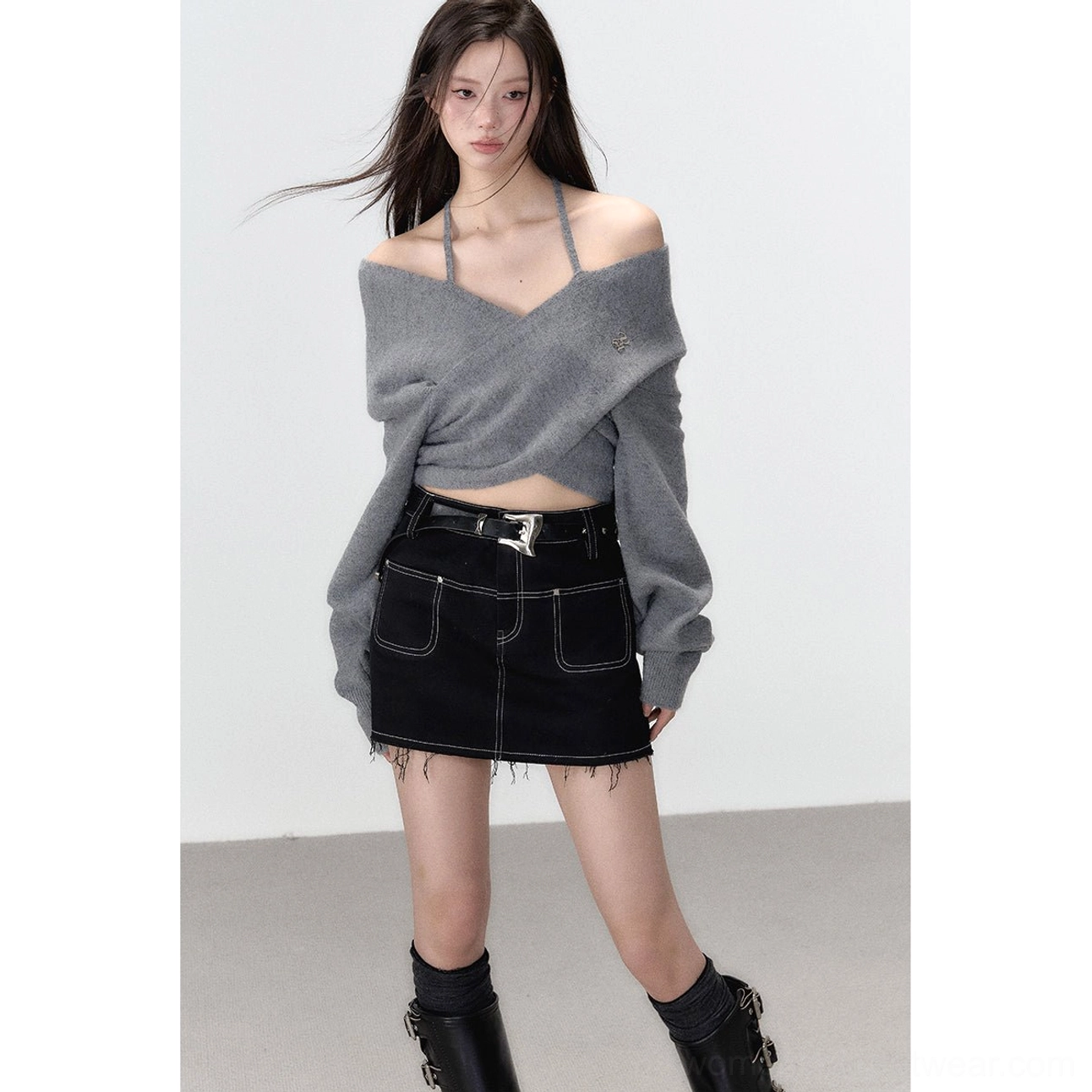 Full body outfit featuring a grey crisscross halter cropped knit top, black denim mini skirt, exposed waist, and biker boots