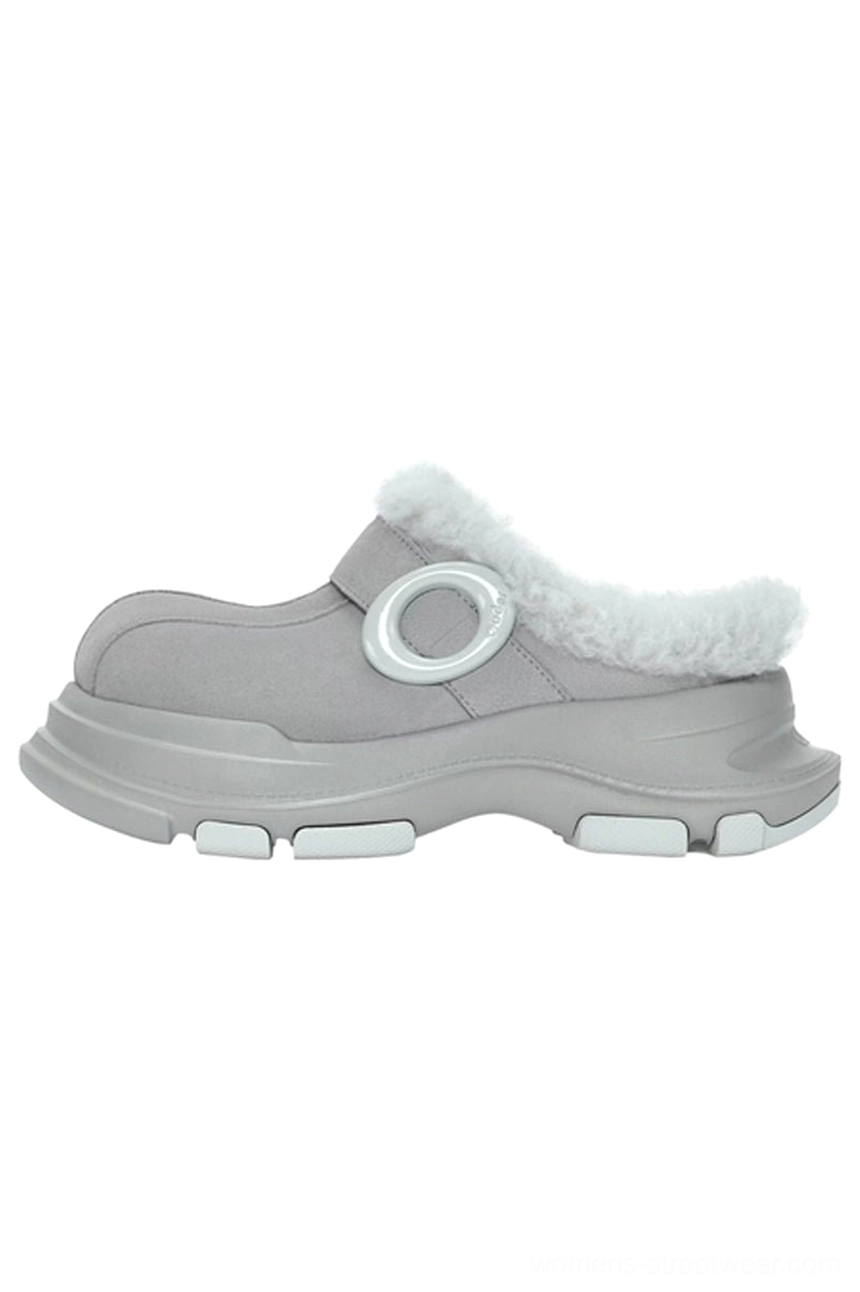 Grey faux fur lined platform clog slipper shown from the left side with matte suede-look upper, fluffy collar, circular ring strap detail, and chunky rubber outsole