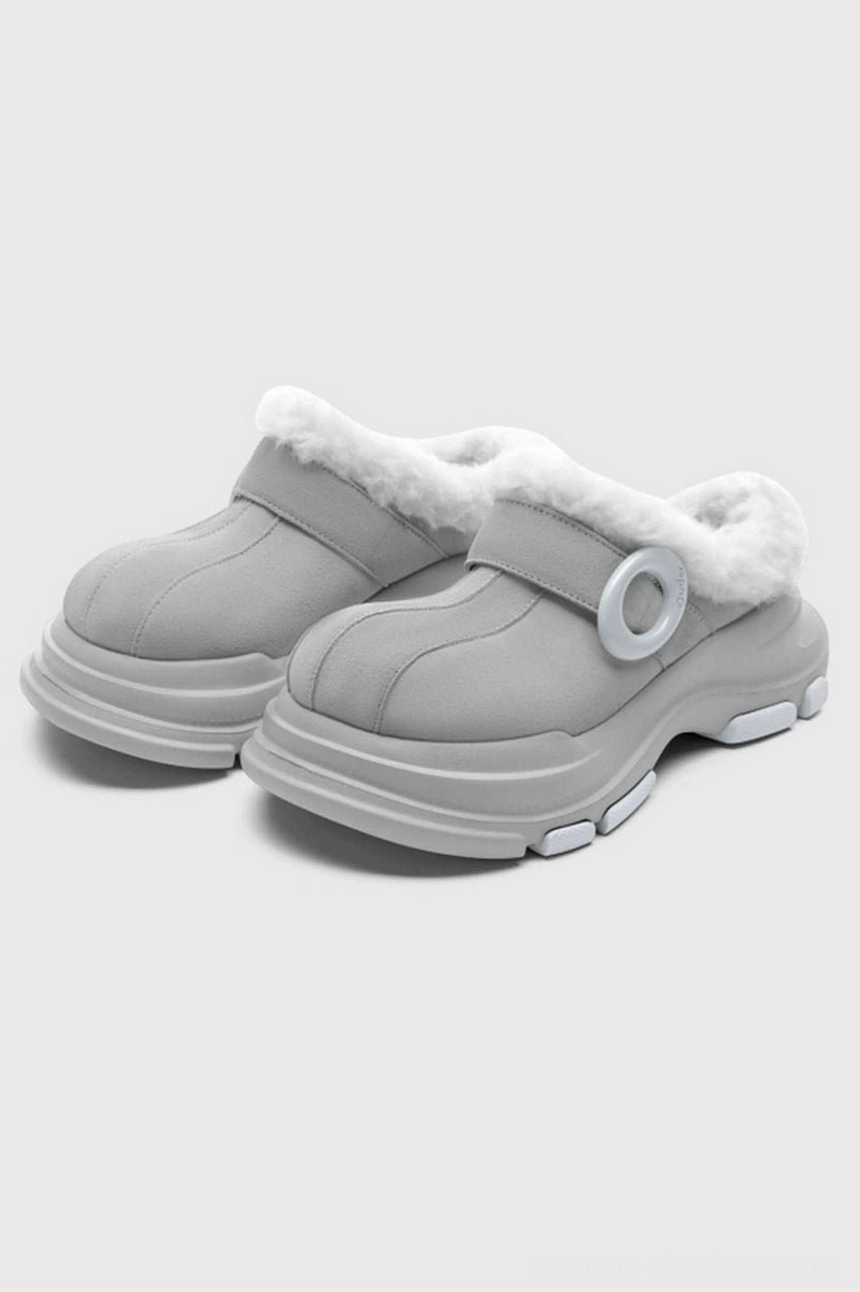 Grey faux fur lined platform clogs in a front three-quarter view with circular ring hardware, matte upper, fluffy trim, and thick block platform sole