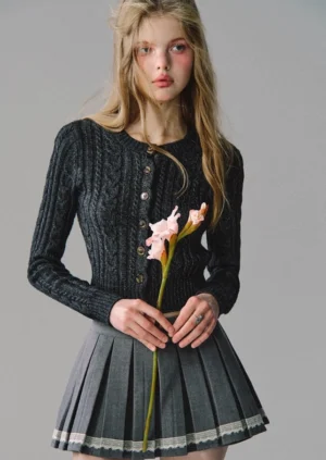 Grey pleated mini skirt with white lace trim paired with black cropped cardigan and platform boots - front half-body streetwear look
