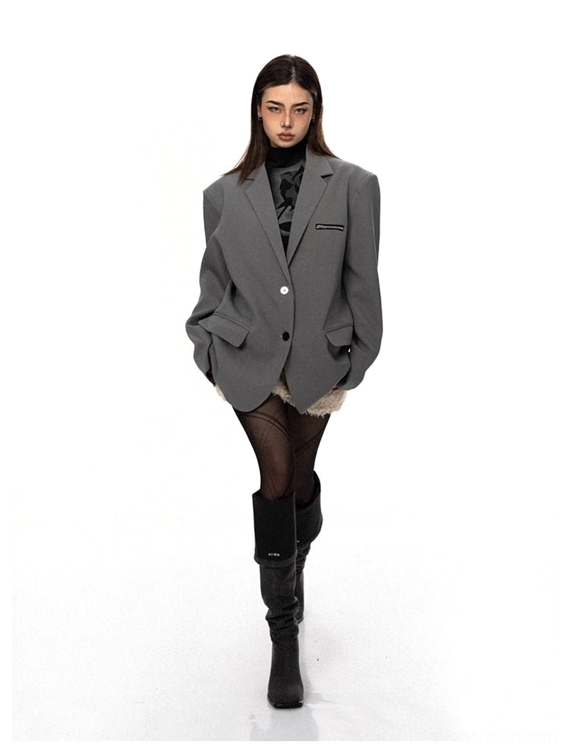 Grey oversized zip-pocket tailored blazer styled with a turtleneck fishnet stockings and knee-high boots in a modern streetwear look