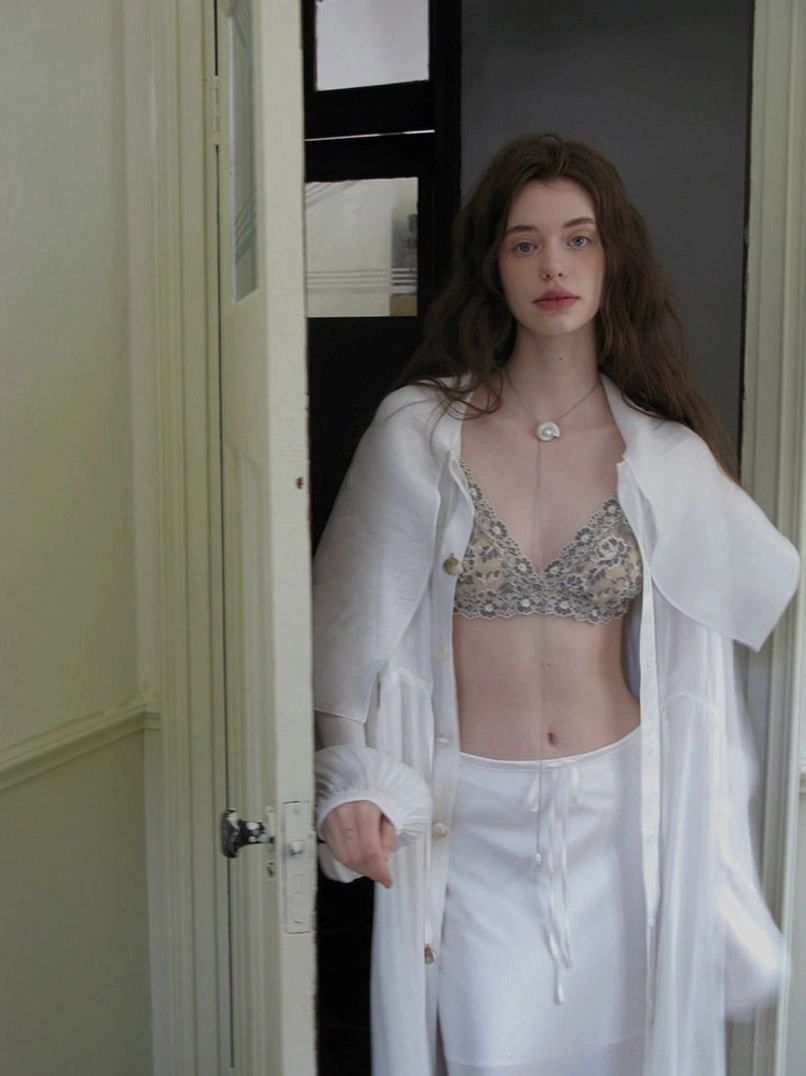 Brown floral lace bralette with sheer white outerwear satin skirt and pearl necklace in a contemporary layered outfit