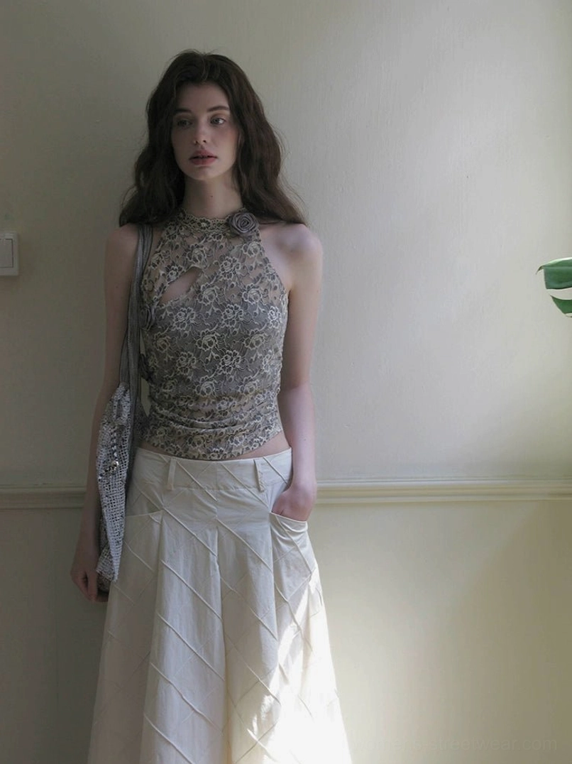 Model wearing a grey floral peony lace halter camisole with a high waisted white pleated midi skirt and shoulder bag