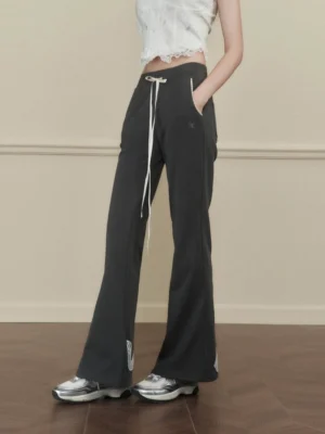 Grey ribbon lace hem flared sweatpants styled with a cropped lace top and chunky sneakers in a vintage studio front view