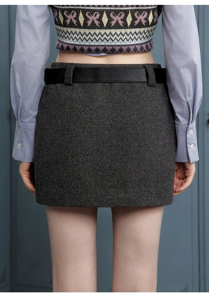 Grey slim-fit mini skirt front detail with wide belt-style waistband, textured fabric, and understated hem embroidery