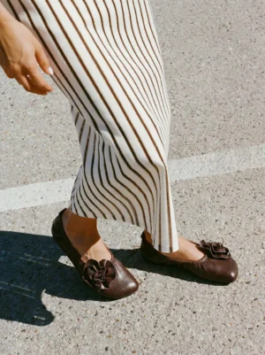 Women wearing coffee leather flower square-toe ballet flats with striped midi skirt outdoors
