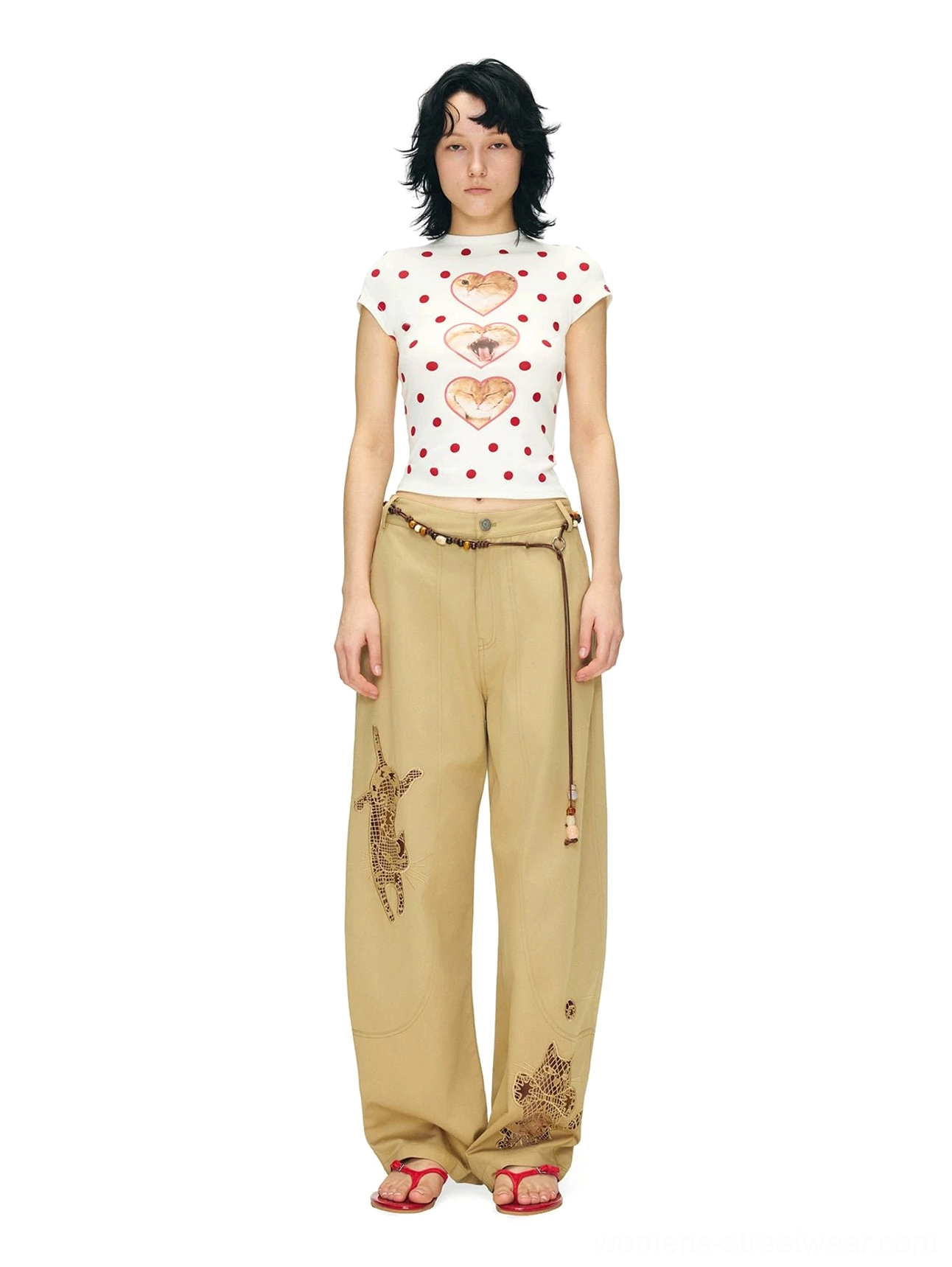 Full-length view of a fitted cropped heart cat polka dot T-shirt styled with high-waisted khaki wide-leg pants and a beaded belt