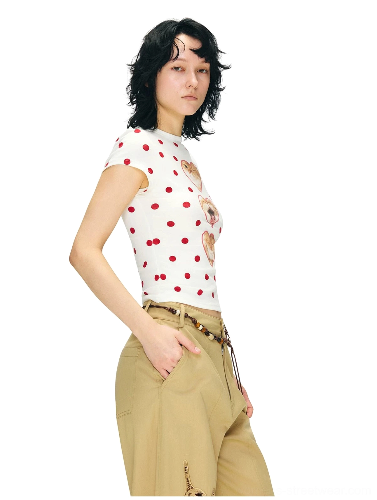 Side three-quarter view of a slim off-white red polka dot T-shirt with partially visible heart-framed cat prints