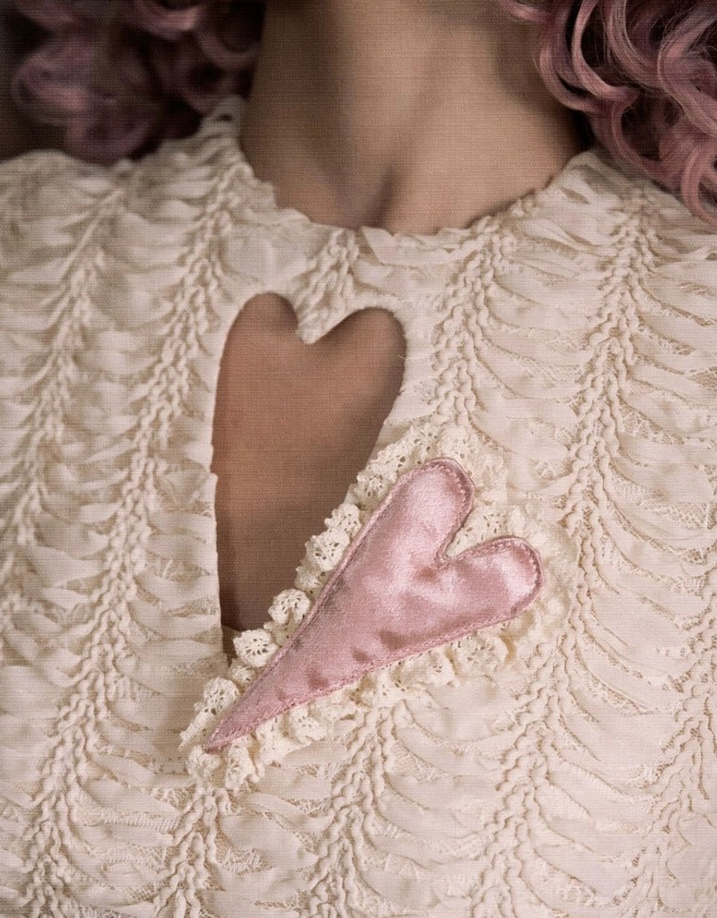 Detailed heart-shaped cutout neckline on a romantic cream lace patchwork corset top with intricate ruching and decorative heart appliqué