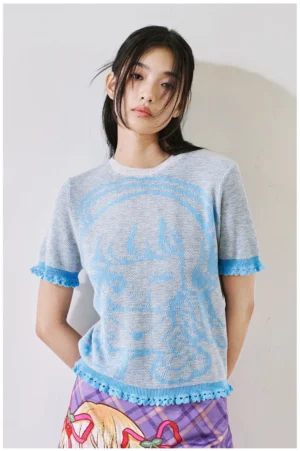 Heather gray anime character cropped knit top with light blue jacquard graphic and blue ruffle trim front view