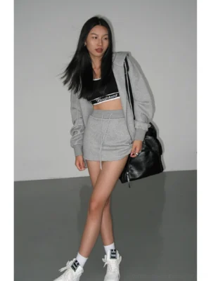 Heather gray drawstring waist mini skirt styled with a cropped sport top and oversized hoodie