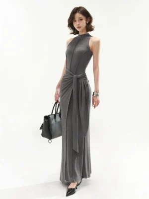 Heather gray sleeveless mock neck tie waist maxi dress shown in a full body side view with a fitted seamed bodice and floor length skirt