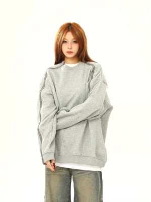 Heather gray oversized crewneck sweatshirt with exposed sleeve zippers shown in side pose