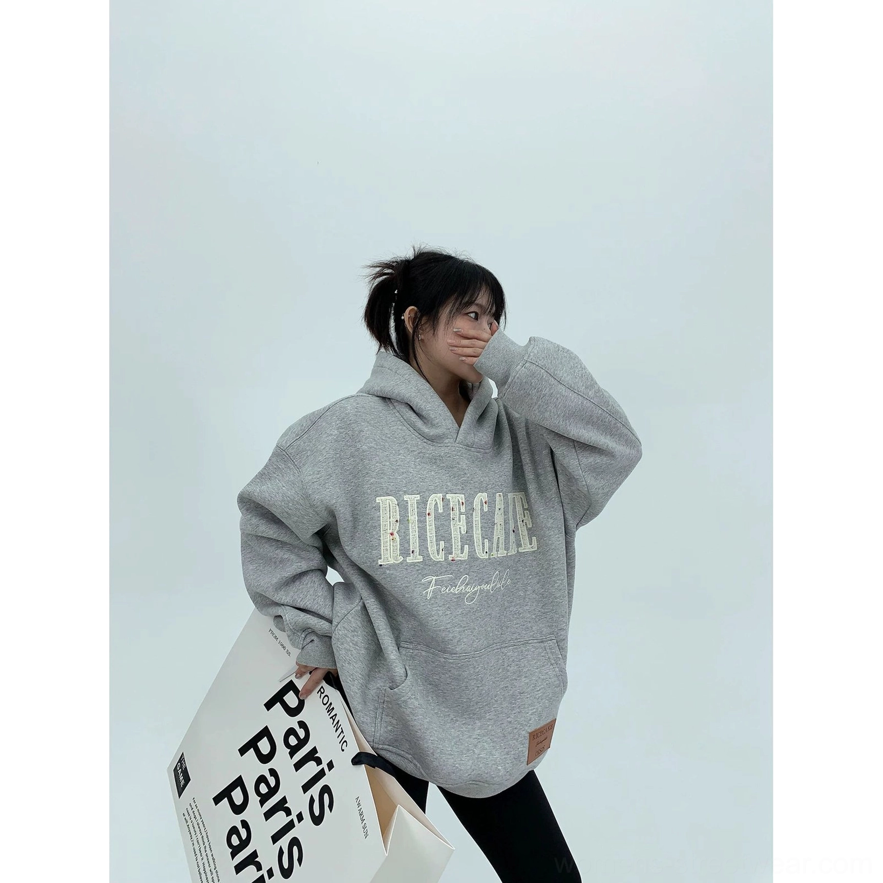 Three-quarter view of a heather gray oversized graphic hoodie with roomy hood, drop shoulders, and casual East Asian streetwear styling