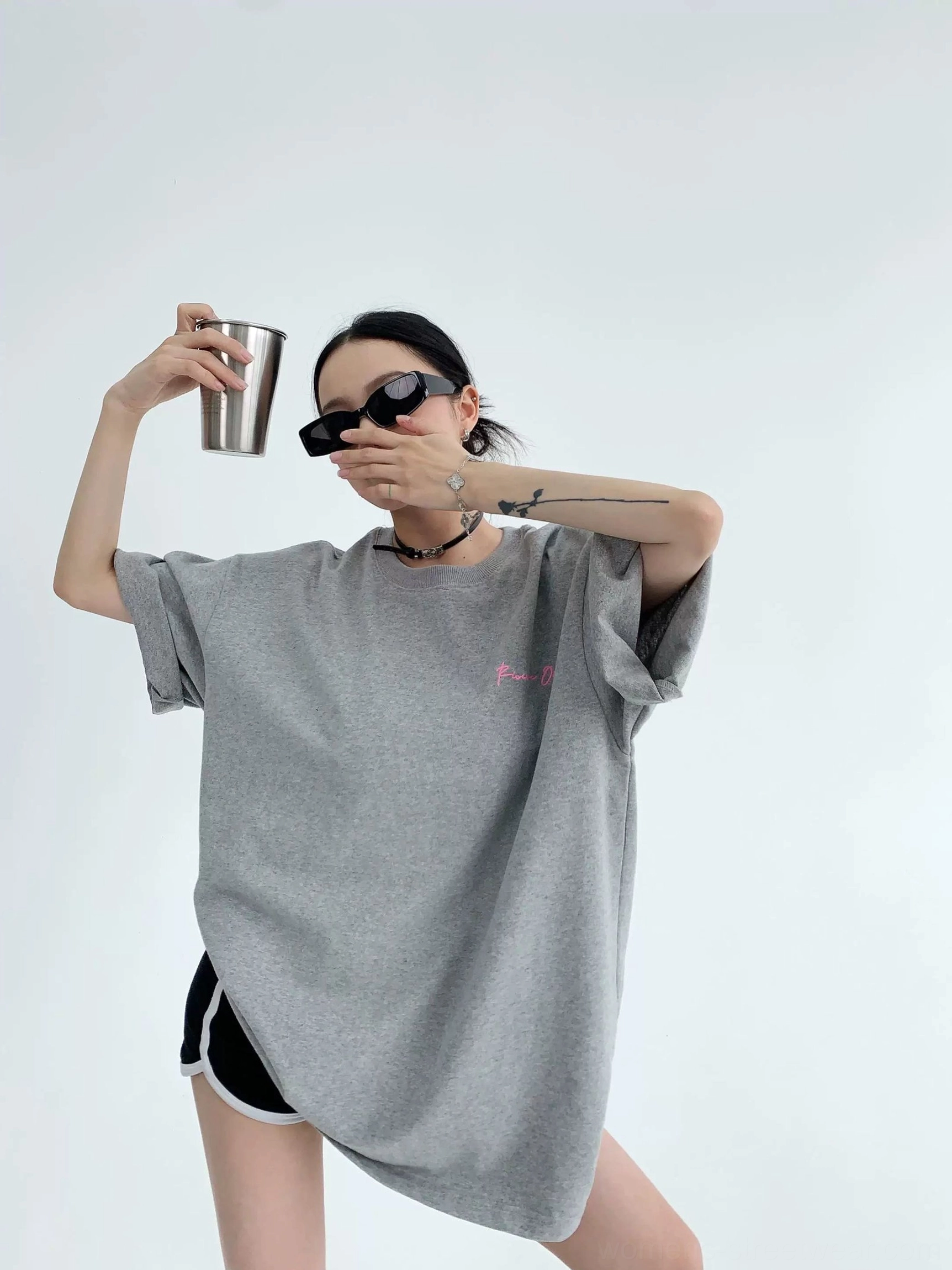 Heather gray oversized cotton streetwear T-shirt shown from the front three-quarter view with small chest print and rolled short sleeves