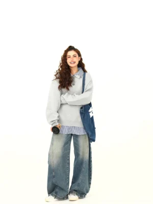 Heather gray oversized polo knit sweater shown from the back three-quarter view with wide-leg jeans and denim tote styling