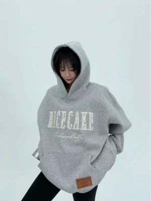 Heather gray oversized streetwear hoodie worn with the hood up, featuring relaxed drop shoulders, bold front graphic, and kangaroo pocket