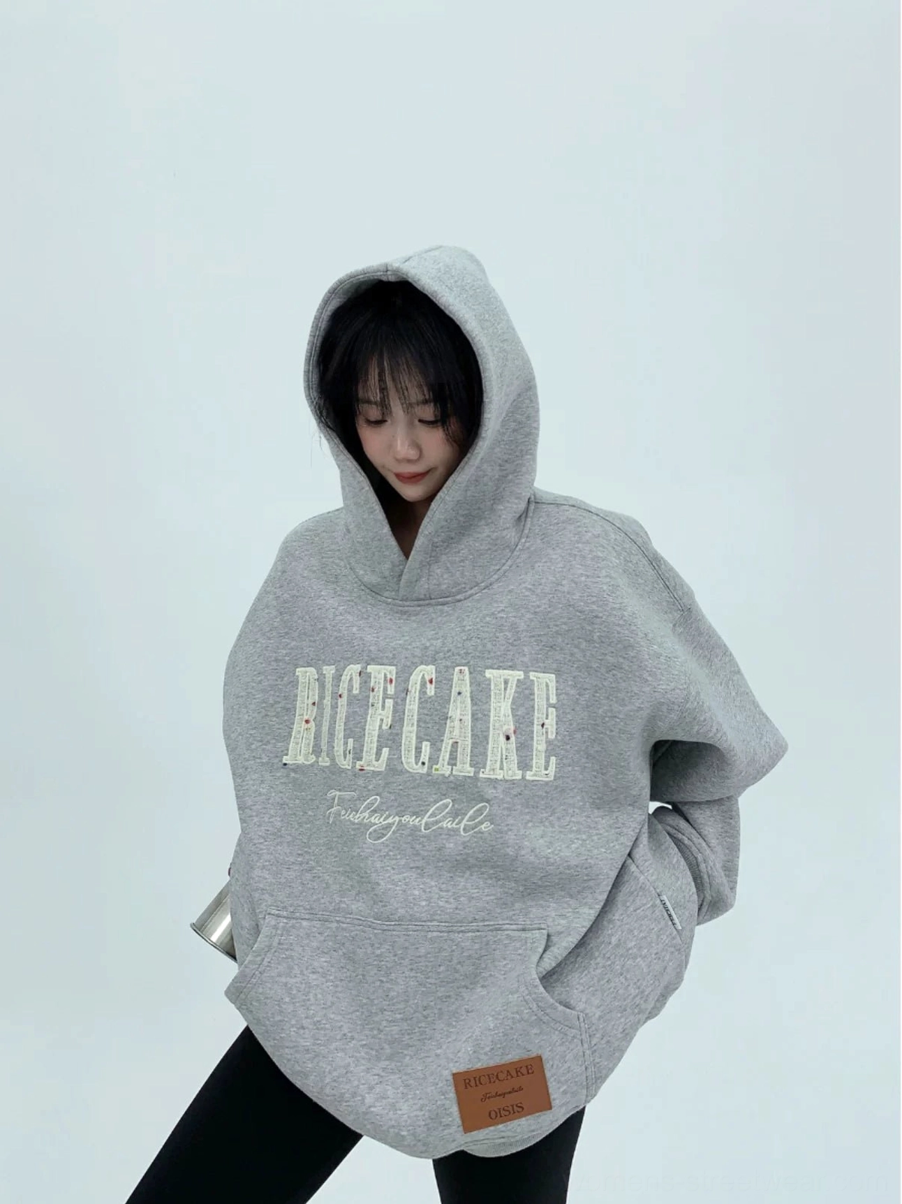 Heather gray oversized streetwear hoodie worn with the hood up, featuring relaxed drop shoulders, bold front graphic, and kangaroo pocket