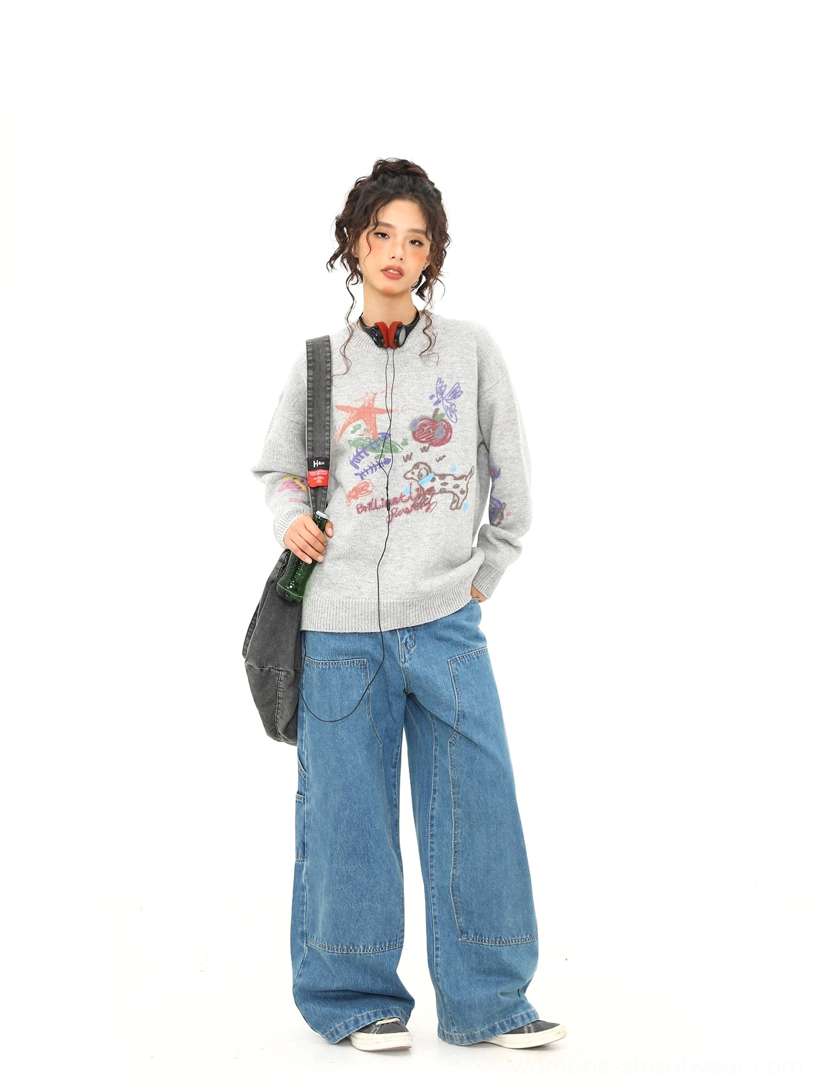 Full body front styling of heather gray puppy doodle sweater paired with relaxed blue jeans and a black tote bag