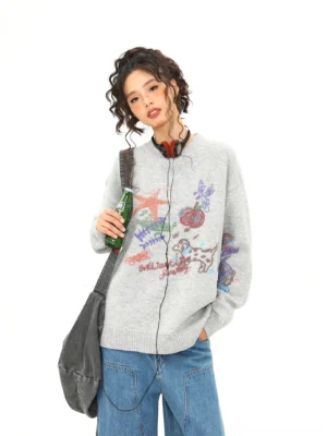 Heather gray puppy doodle oversized knit sweater worn with wide-leg blue jeans in a three-quarter front studio view