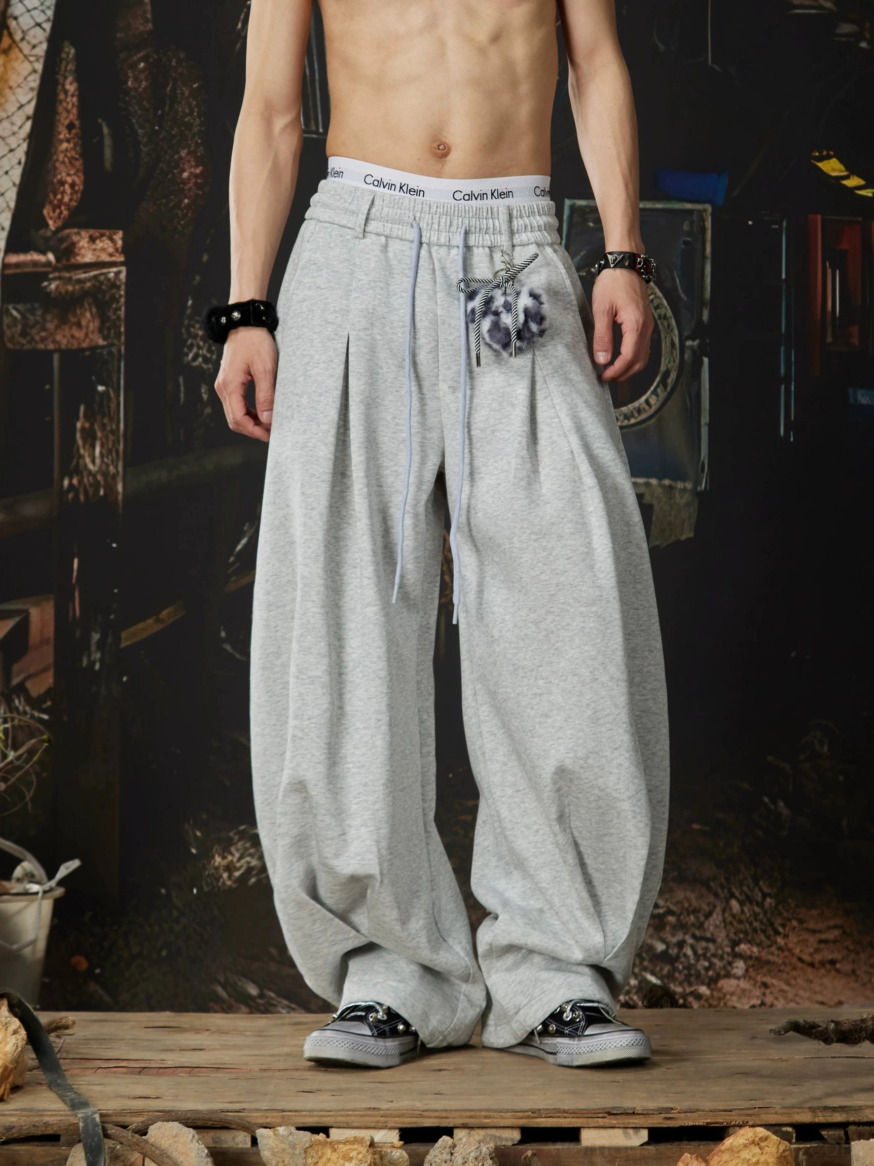 Heather grey gothic streetwear sweatpants close-up showing drawstring elastic waist front pleats sneakers and fuzzy leopard charm