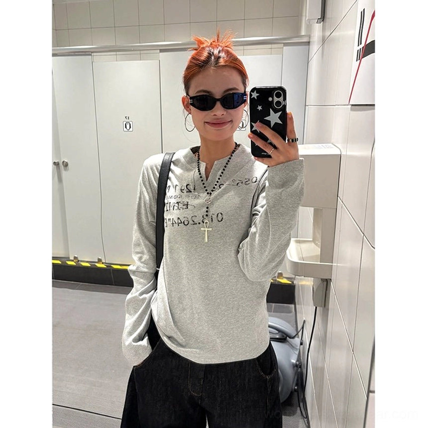 Close-up front view of a heather grey Henley long-sleeve top with notched neckline cross pendant necklace and relaxed fit
