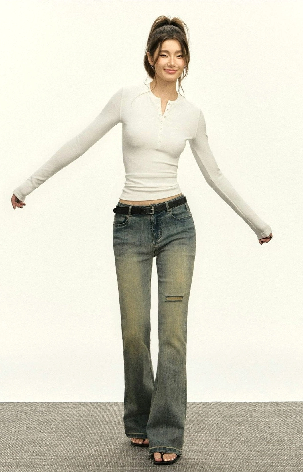 Heather grey ribbed Henley long-sleeve crop top with fitted silhouette and half-button neckline worn with flared jeans