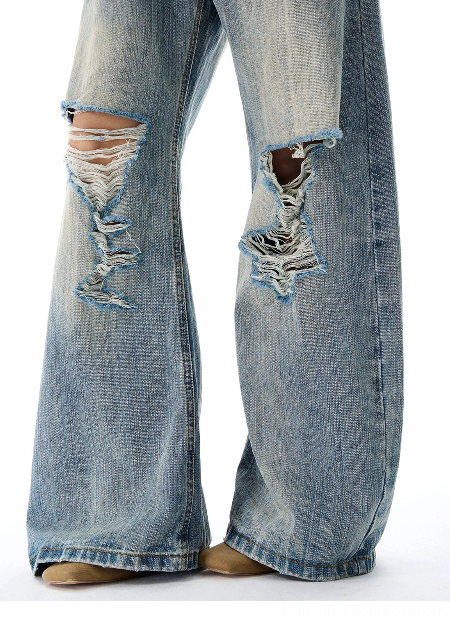 Heavy frayed knee distressing detail on vintage blue wide leg denim jeans