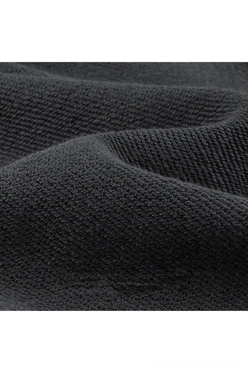 Close-up view of thick dark gray heavyweight cotton knit texture from an oversized long sleeve polo sweater