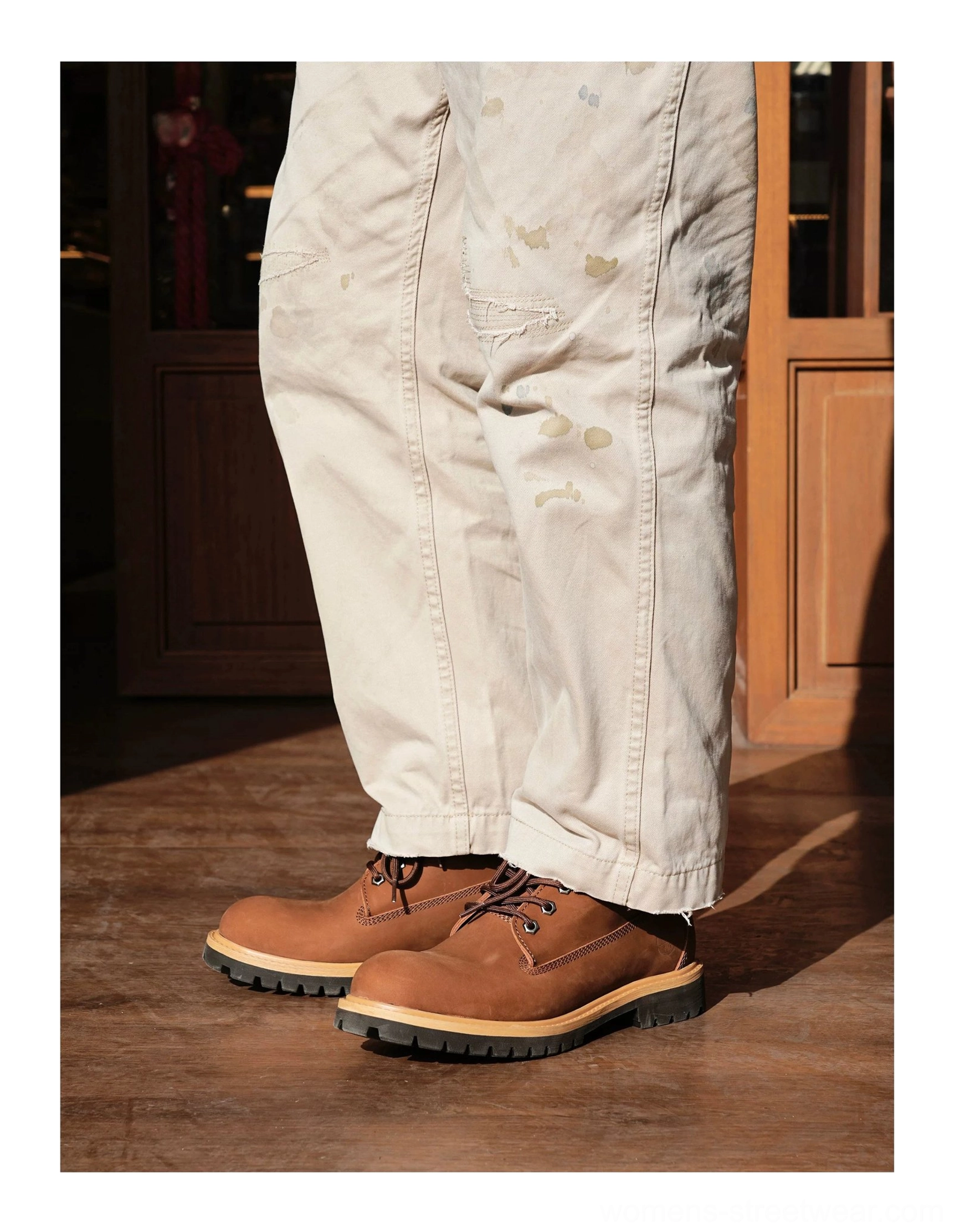 Brown leather lug sole work boots styled with relaxed work trousers in a low leg side-view streetwear look