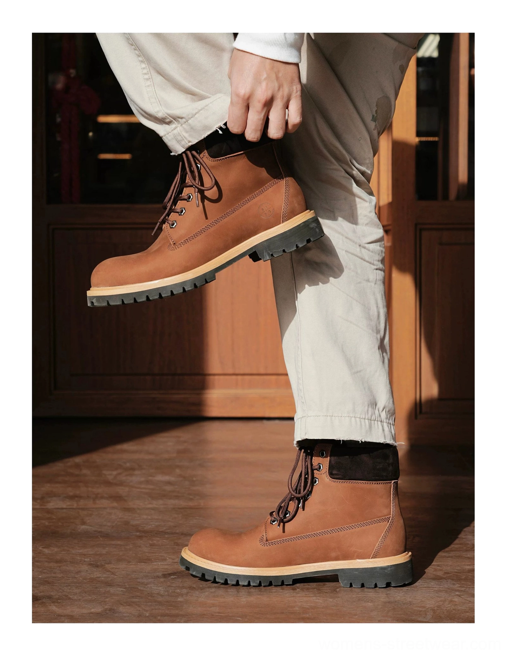 Heritage lace-up leather work boots with thick treaded rubber outsole styled with khaki pants side profile