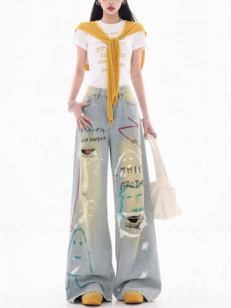 Front view of high-rise graffiti wide-leg jeans with faded blue acid-wash denim, relaxed loose fit, painted artwork, and distressed streetwear details