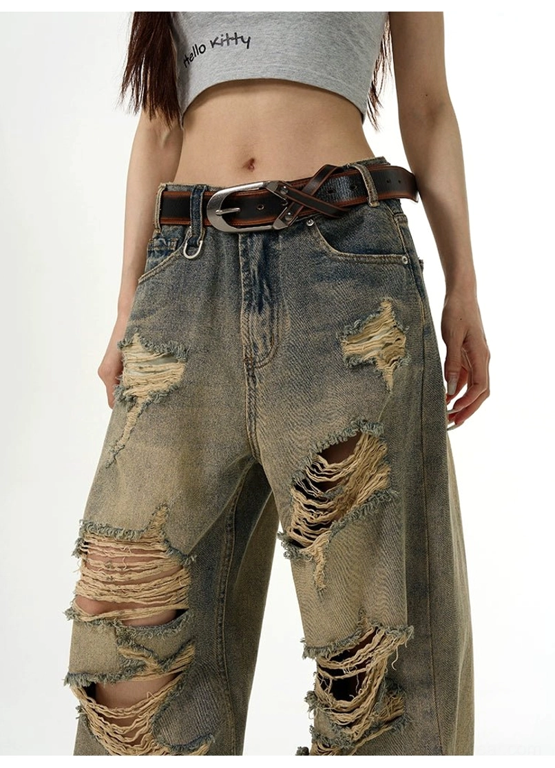 Close-up of the high-rise waist and large shredded ripped details on vintage washed retro blue denim jeans