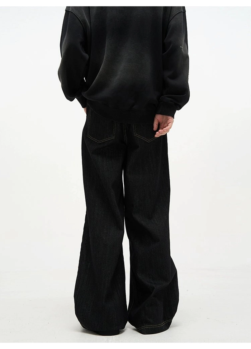 Back full body view of black baggy denim jeans showing rear pockets, relaxed wide leg cut, and dark denim silhouette