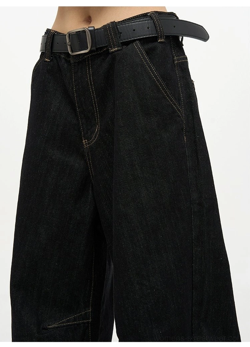 Close-up of the high waist black baggy denim jeans showing contrast topstitching, zip fly area, belt loops, and denim texture