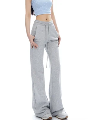 Flower Ash high-waist flared sweatpants shown in a front full-body studio view with drawstring waist, side pockets, and long flared hem