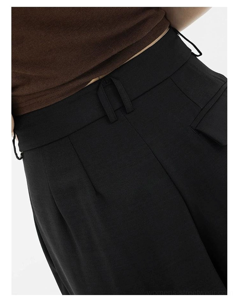 Close-up of black high-waist palazzo streetwear pants waistband with belt loops and front pleats