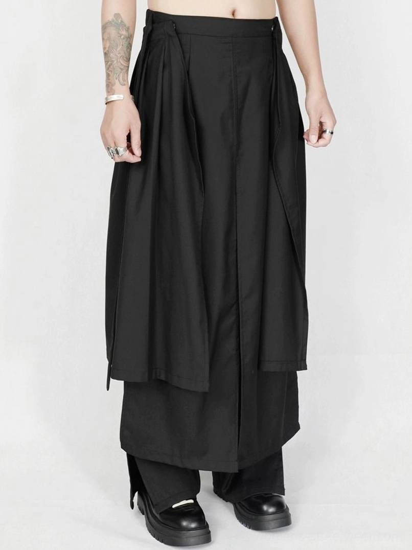 Front close-up of high-waisted black apron-style draped wide-leg avant-garde trousers