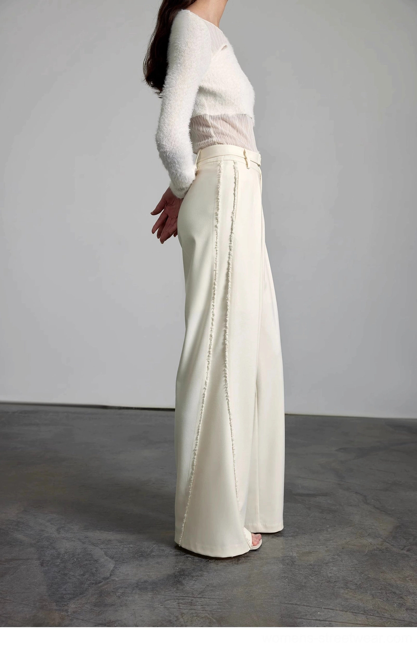 Back side profile of high-waisted cream wide-leg trousers with visible decorative side stitching