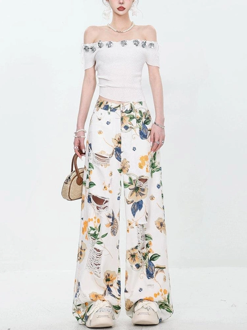 Full front view of high-waisted floral print distressed wide-leg jeans with relaxed streetwear fit