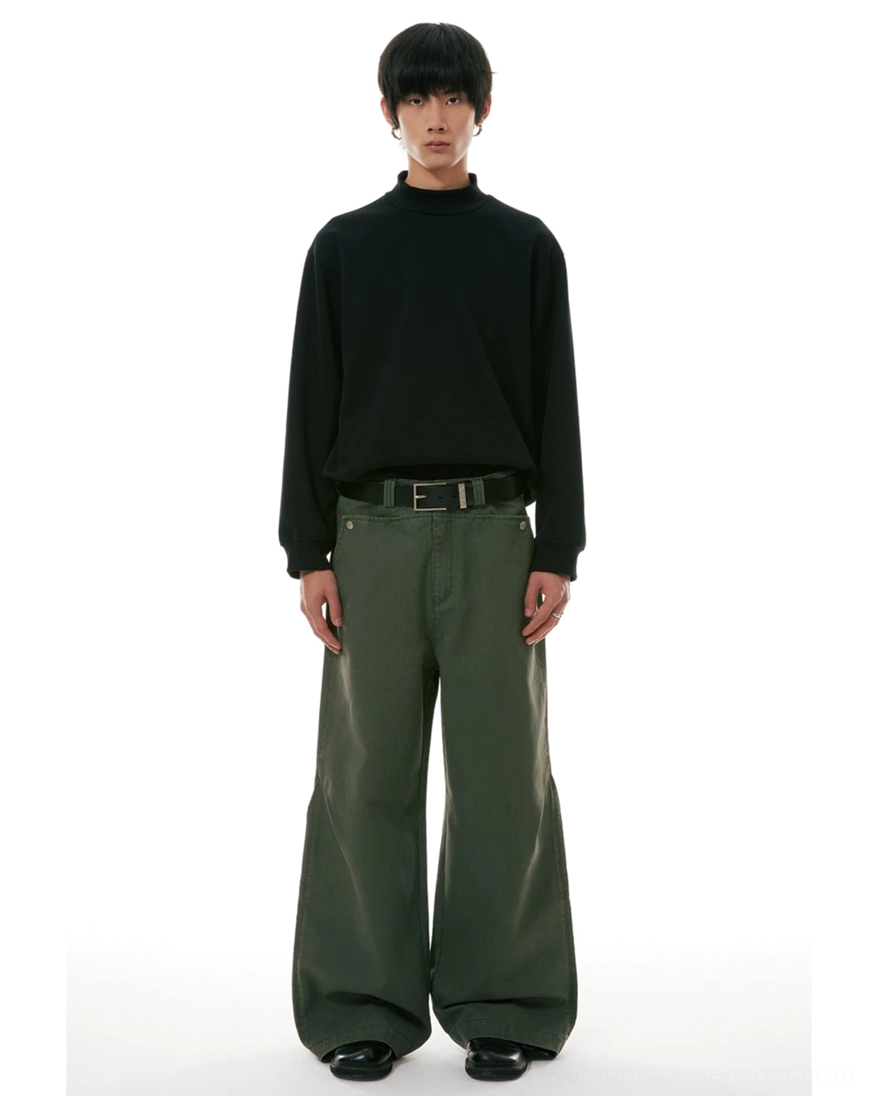 High-waisted olive green wide-leg workwear denim jeans paired with a black fitted turtleneck in a full front view
