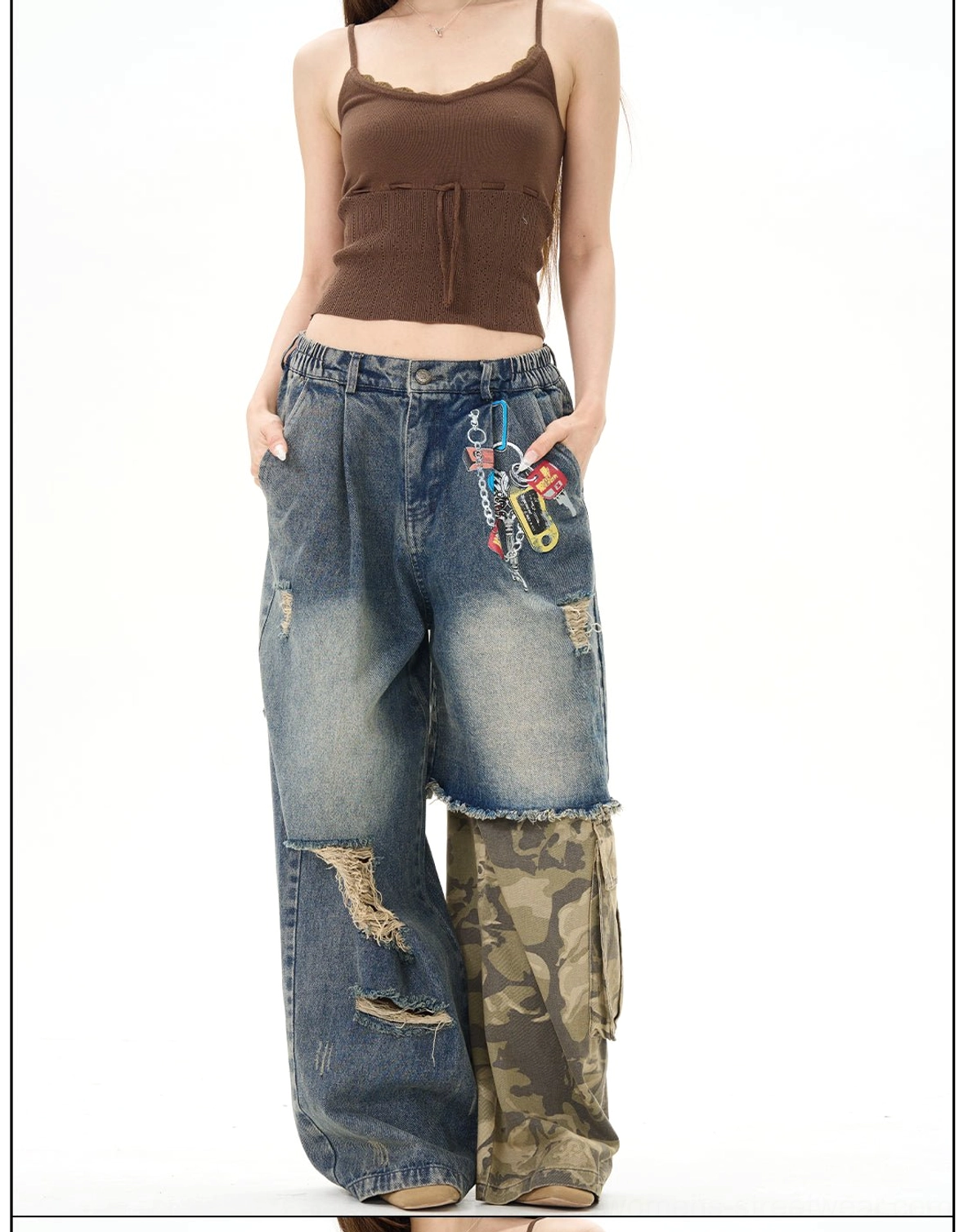 Front view of high-waisted distressed patchwork wide-leg jeans on a female model, showing camo patchwork, ripped denim details, relaxed legs, and keychain-style pocket embellishments