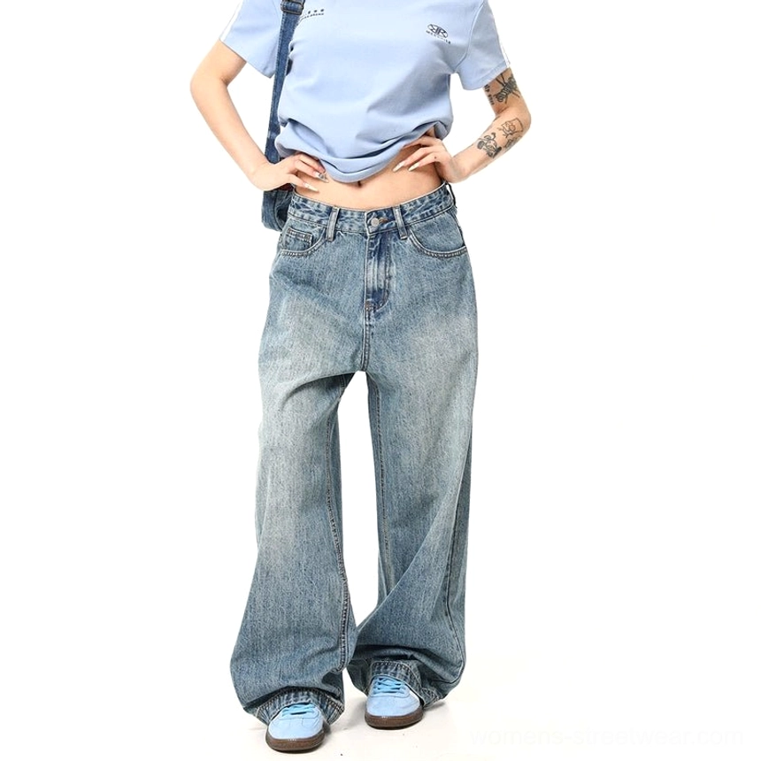 Waist-to-feet detail of women wearing high-waisted retro washed wide-leg jeans with a cropped top and blue sneakers