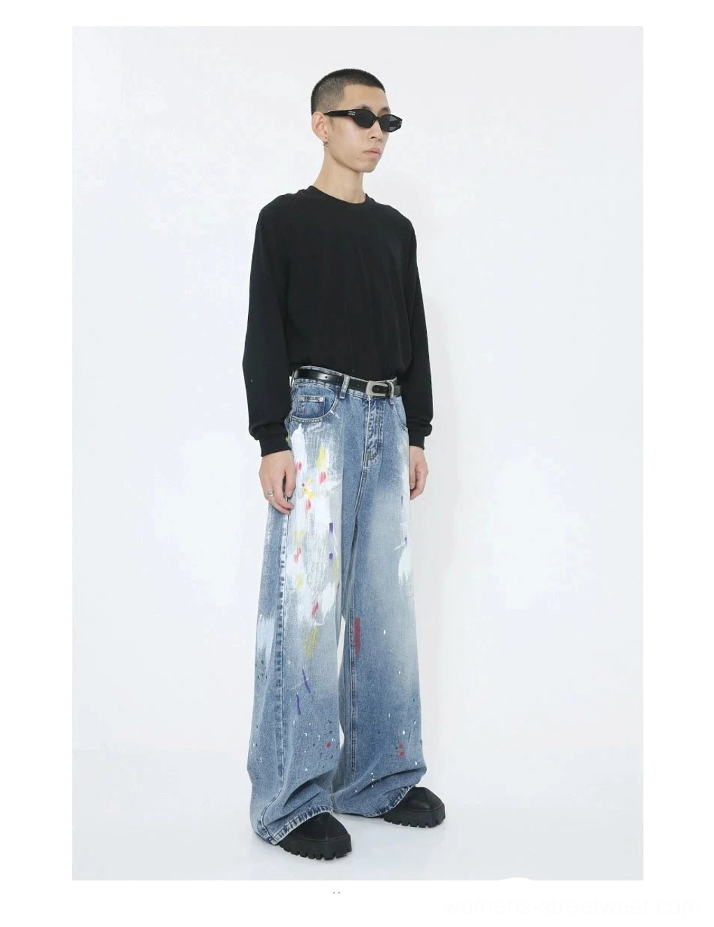Three-quarter front view of high-waisted faded blue splash wide-leg denim jeans with colorful painted graphics and relaxed streetwear proportions