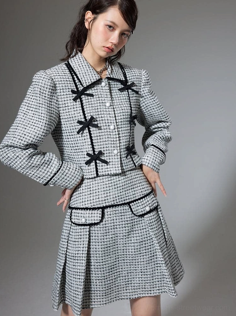 Side view of houndstooth cropped jacket and high waist pleated mini skirt with black braided trim