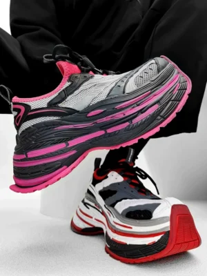 Chunky layered platform sneakers worn with black sweatpants, showing pink black gray and white black red color-block streetwear runner styles