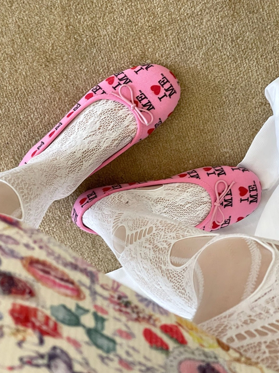Pink heart and letter print ballet flats with small vamp bows styled with white lace socks