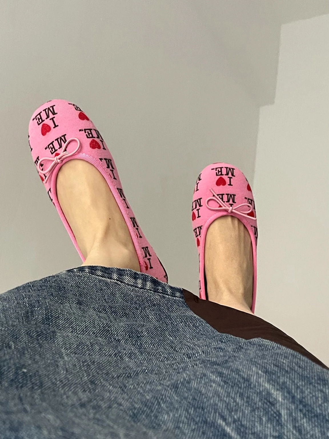 Pink I Love Me print ballet flats worn barefoot with a denim skirt in a casual streetwear outfit