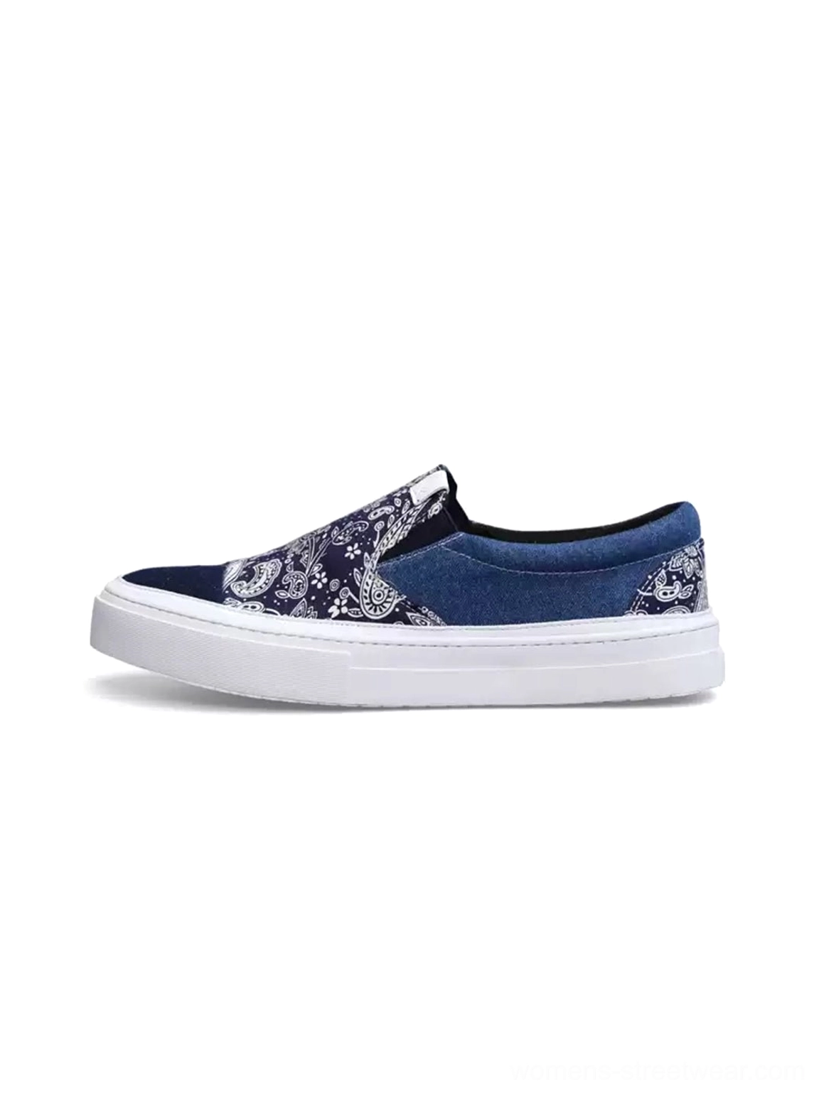 Side profile of indigo blue paisley patchwork slip-on streetwear sneakers with elastic side inserts and thick white rubber sole on a white studio background