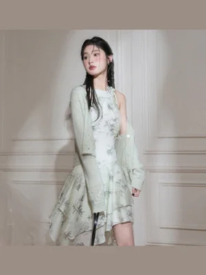 Full length model wearing a green ink bamboo print halter midi dress with asymmetric ruffled hem and oversized grey blazer